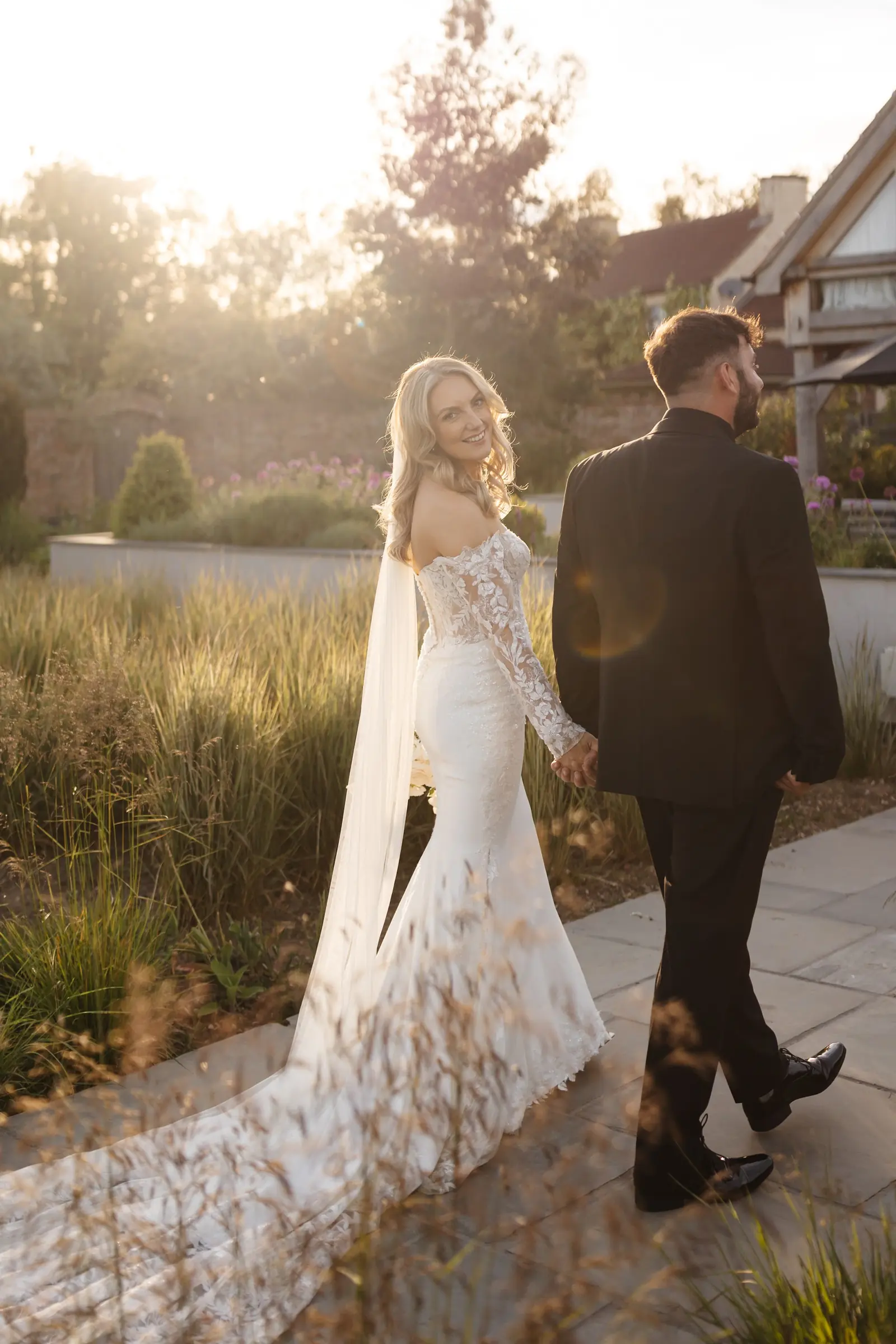 A bride and groom walking in golden evening light
