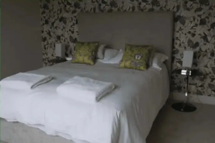 A double bedroom at Bridge View with patterned wallpaper
