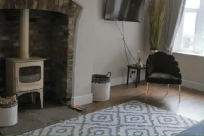 The lounge at Bridge View, with a log burner in the old fireplace