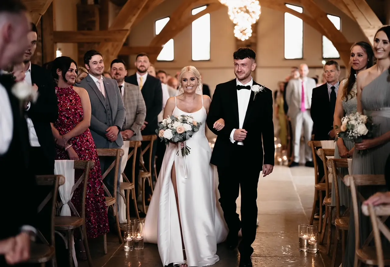 A just-married couple walking back up the aisle of the Ceremony Hall