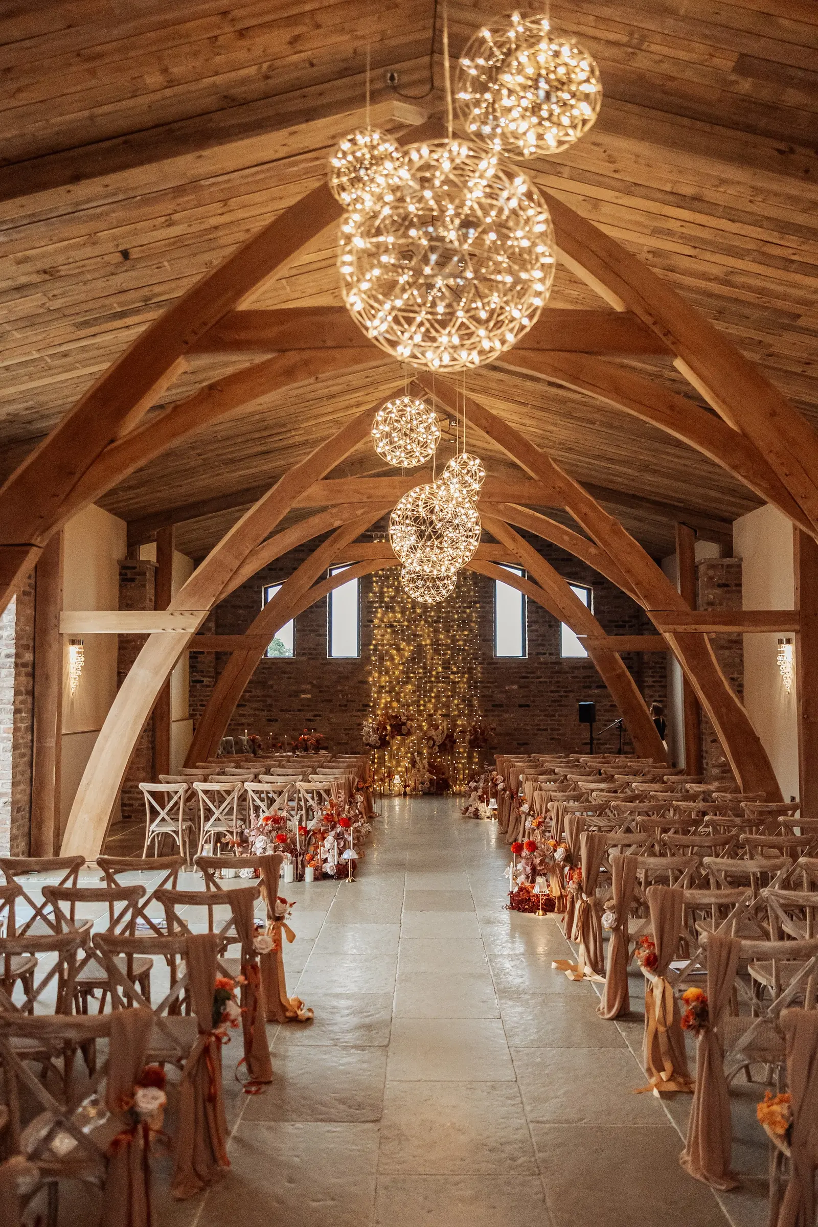 The aisle of the Ceremony Hall beneath its hand-crafted oak arches and globe pendants
