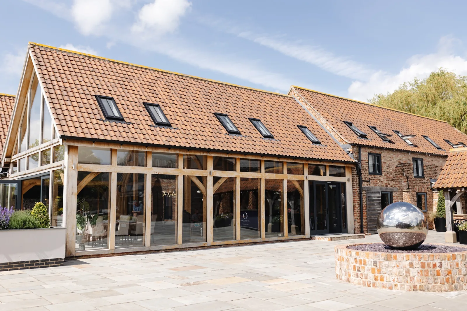 The oak and glass frontage on the courtyard, beside the steel sphere water feature