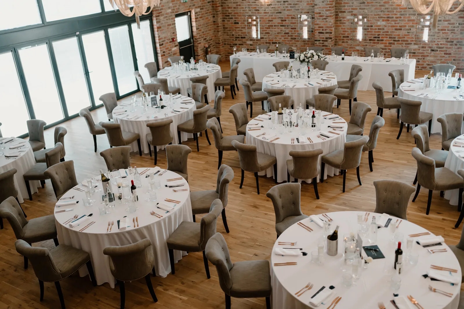 Round tables laid for the wedding breakfast in the Old Grain Store, seen from above