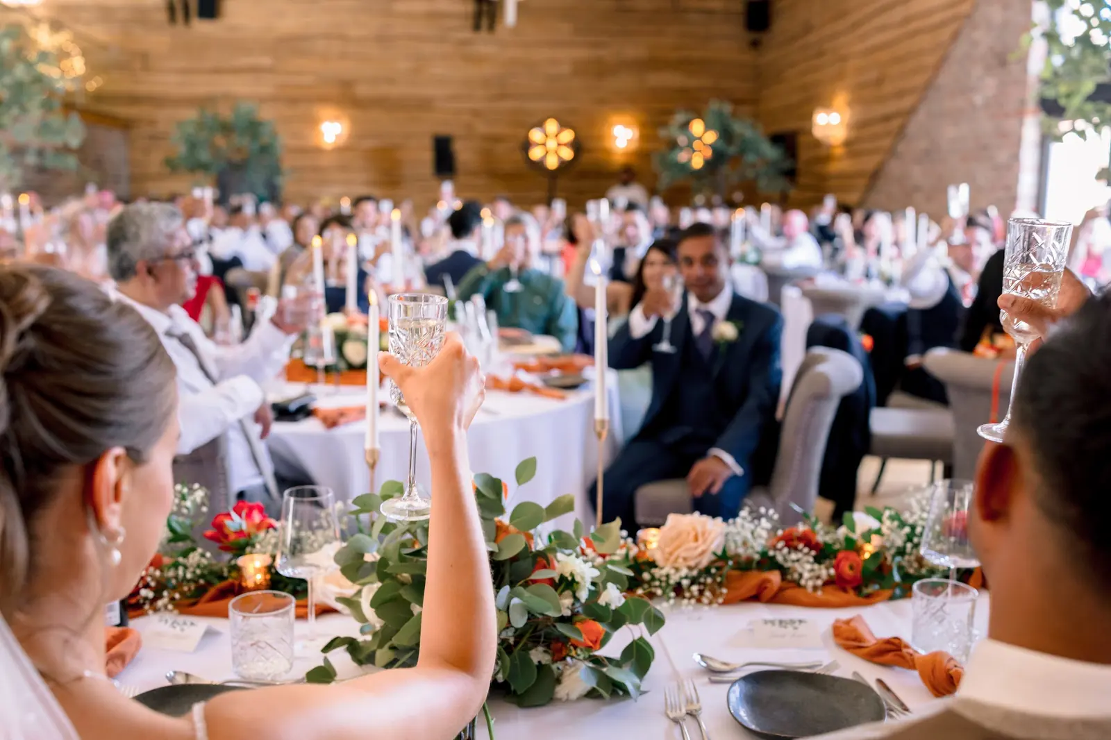 Guests raising a toast at the wedding breakfast in the Old Grain Store