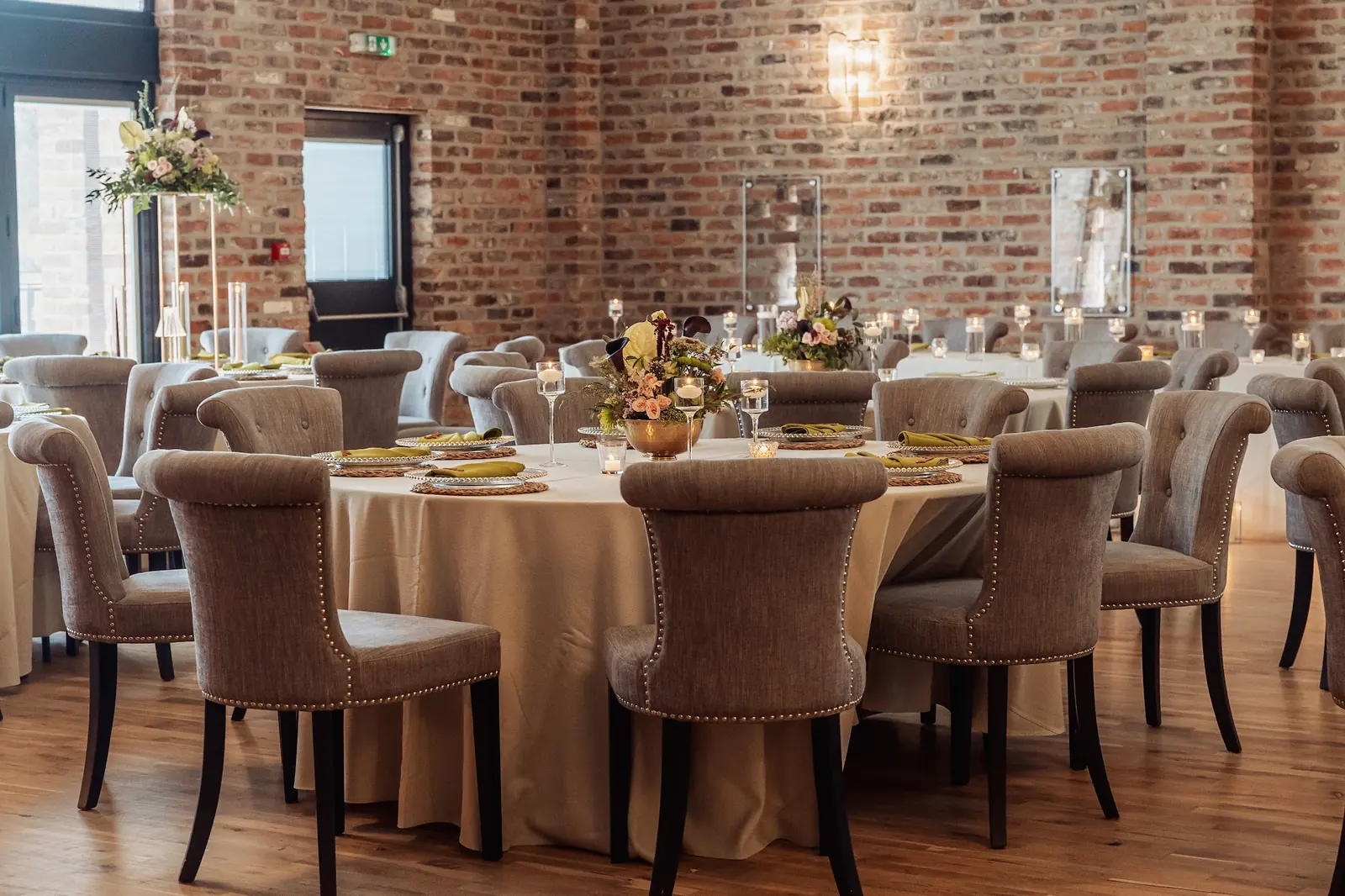 Upholstered chairs around dressed tables in the Old Grain Store
