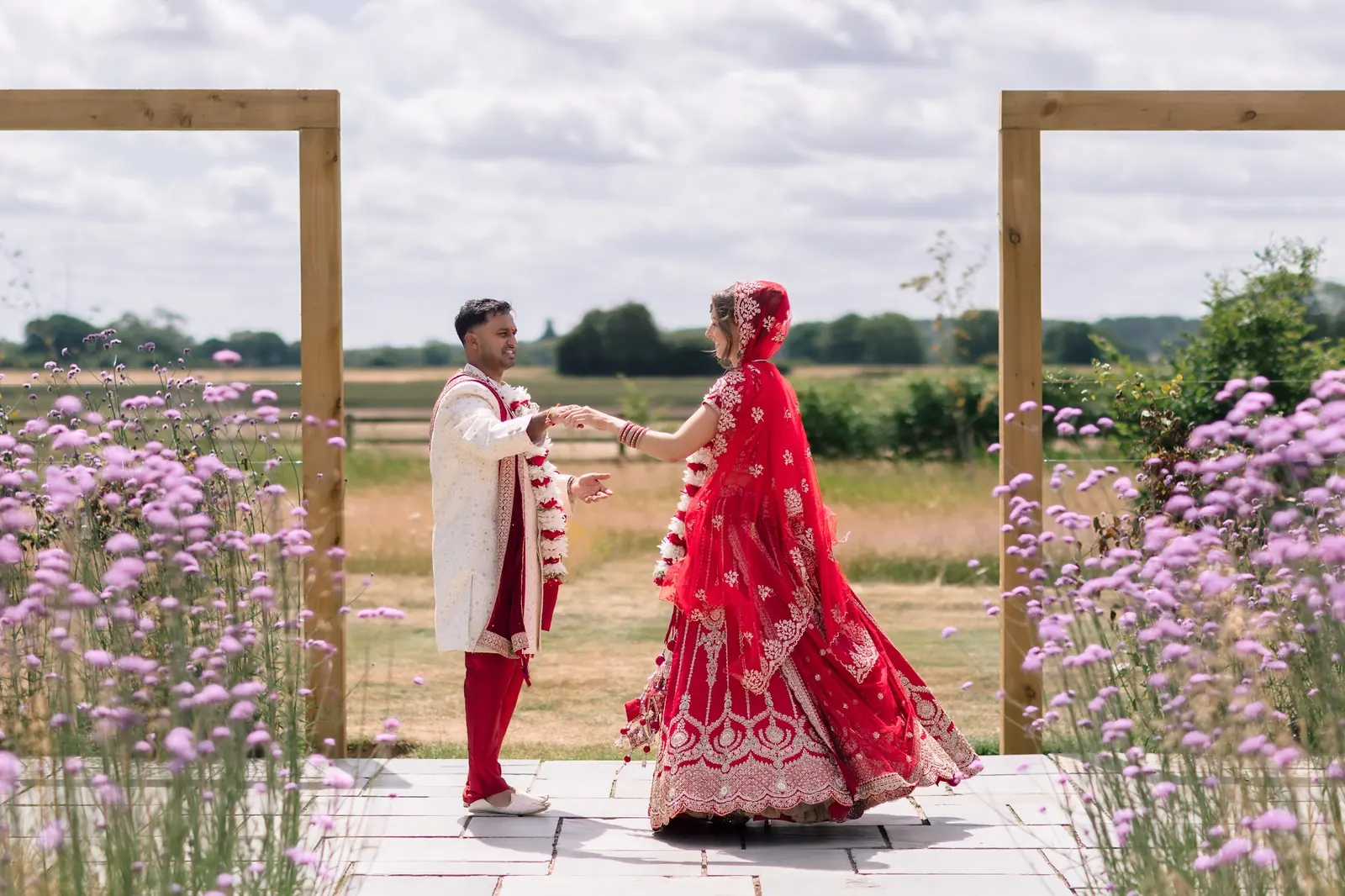 A couple in traditional dress beneath the timber frames
