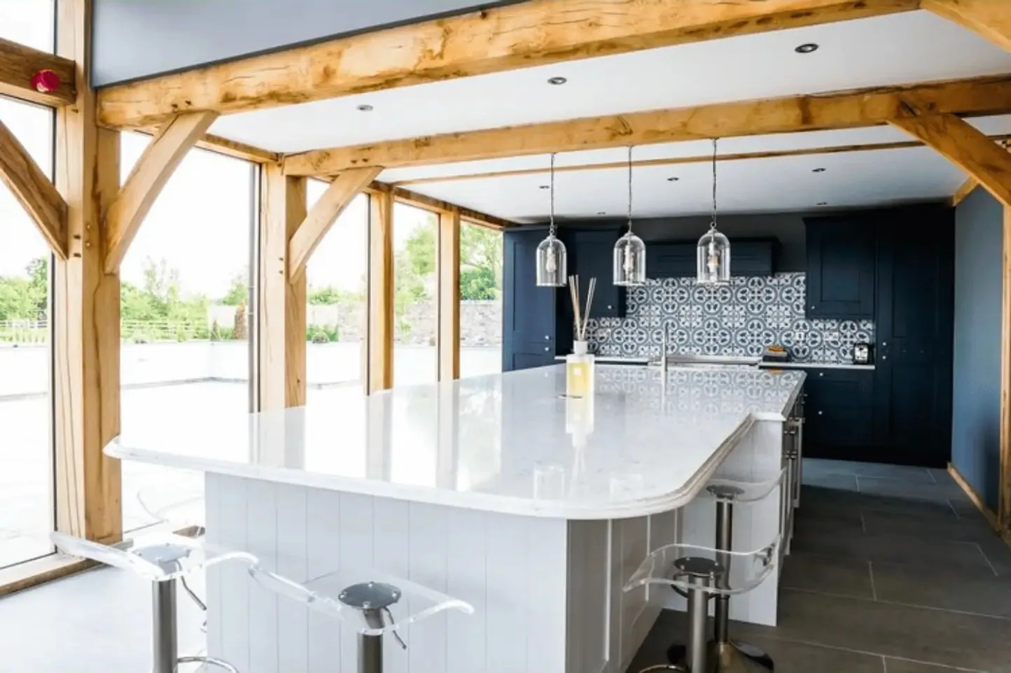 The open-plan kitchen beneath the oak frame of the double-height extension