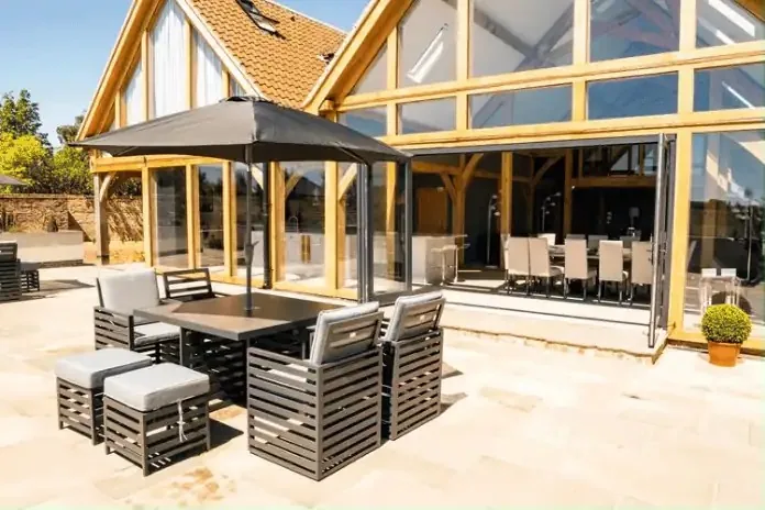 The glass and oak extension opening onto a terrace with outdoor seating