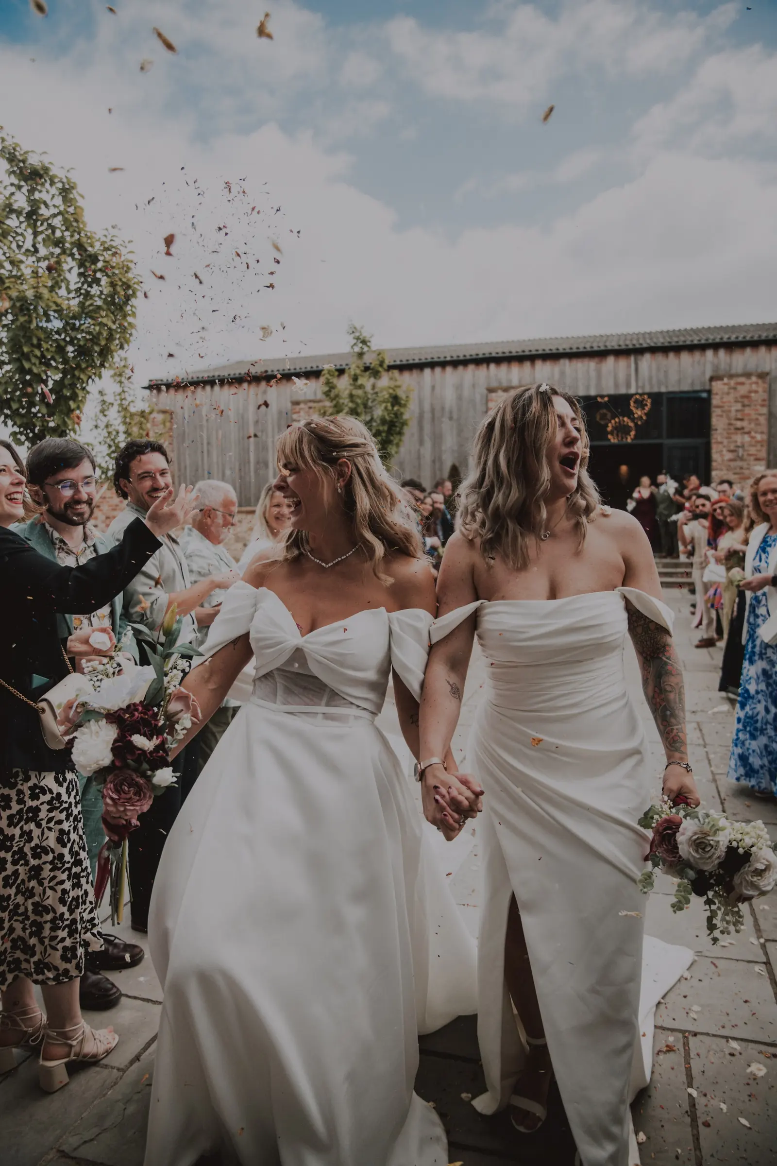 Two brides walking through a shower of confetti