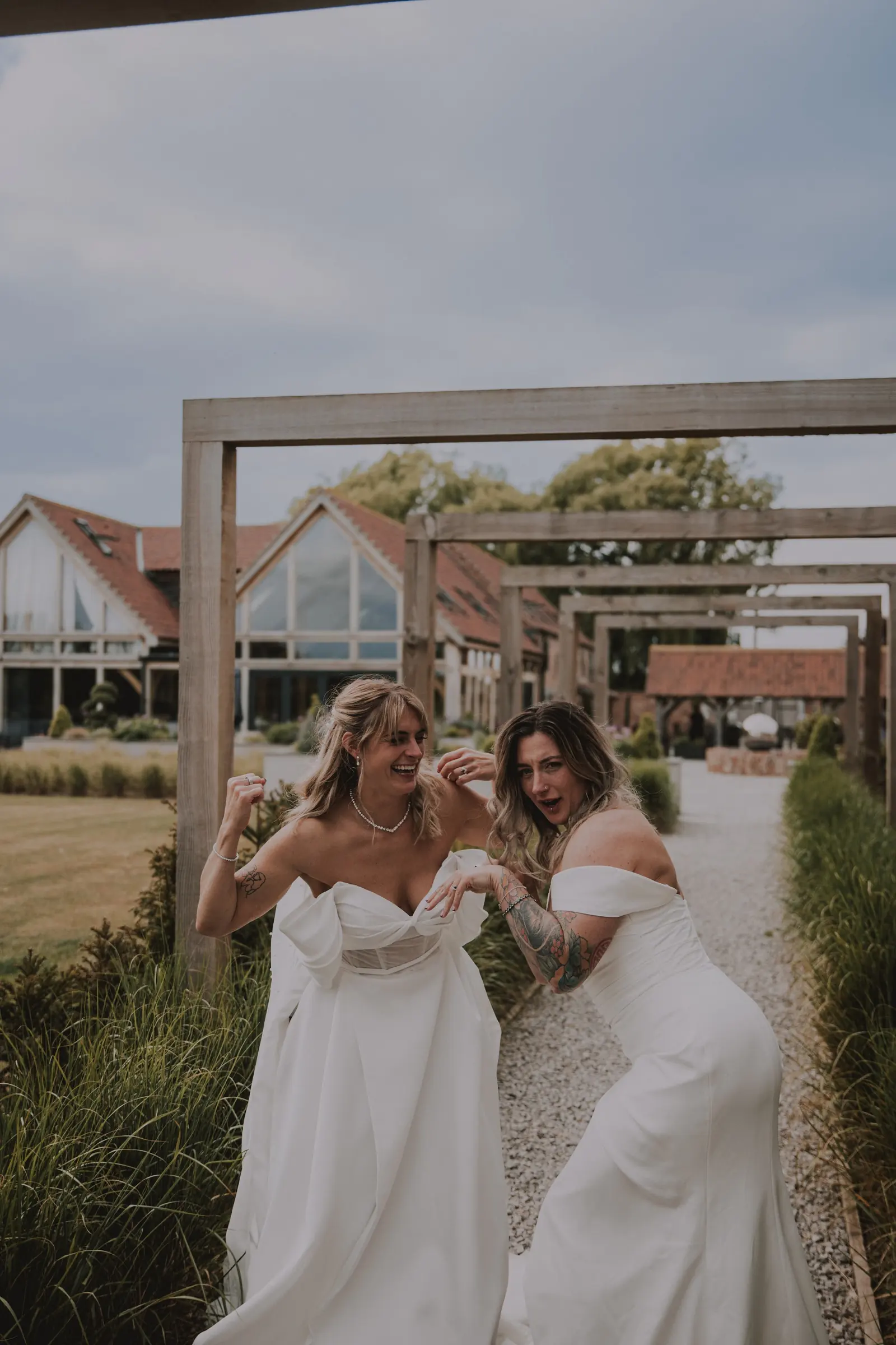 Two brides laughing under the timber frames