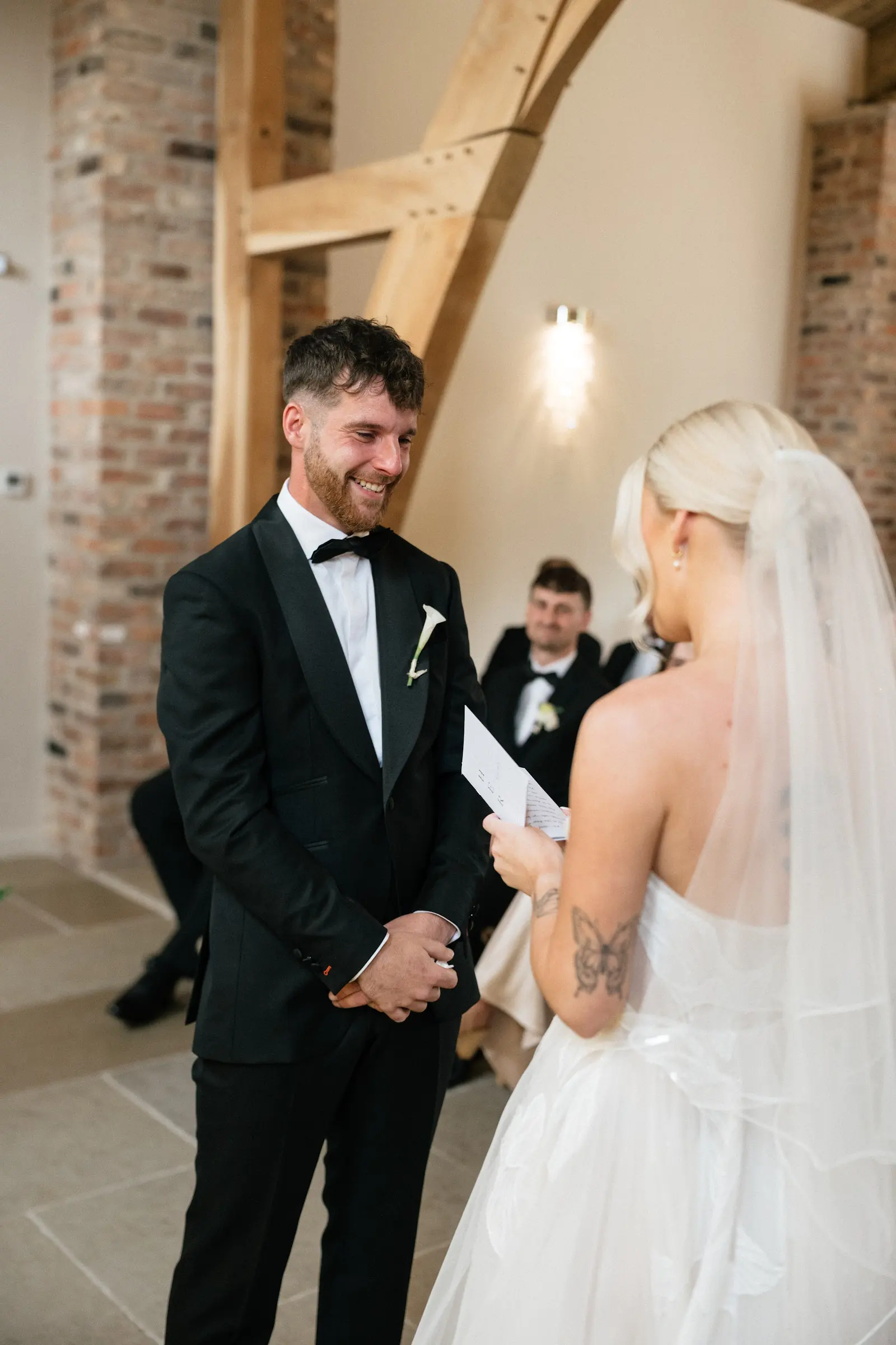 A couple exchanging vows under the oak beams
