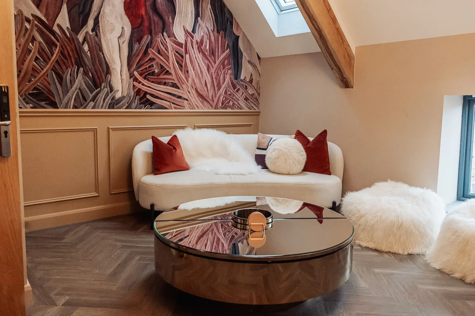 A lounge corner with a botanical mural and a cream sofa