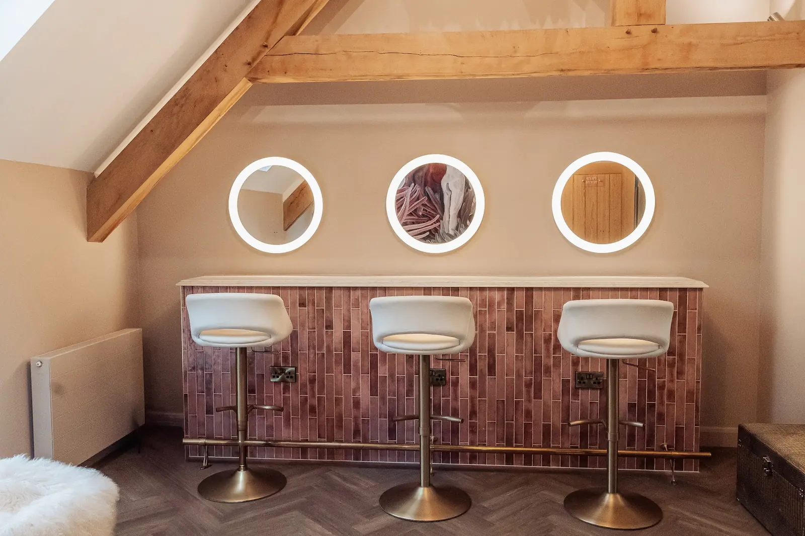 The prep room with three round lit mirrors and bar stools