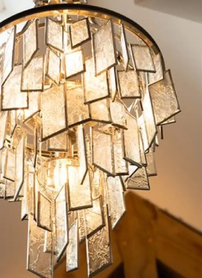 A glass chandelier hanging beneath a skylight