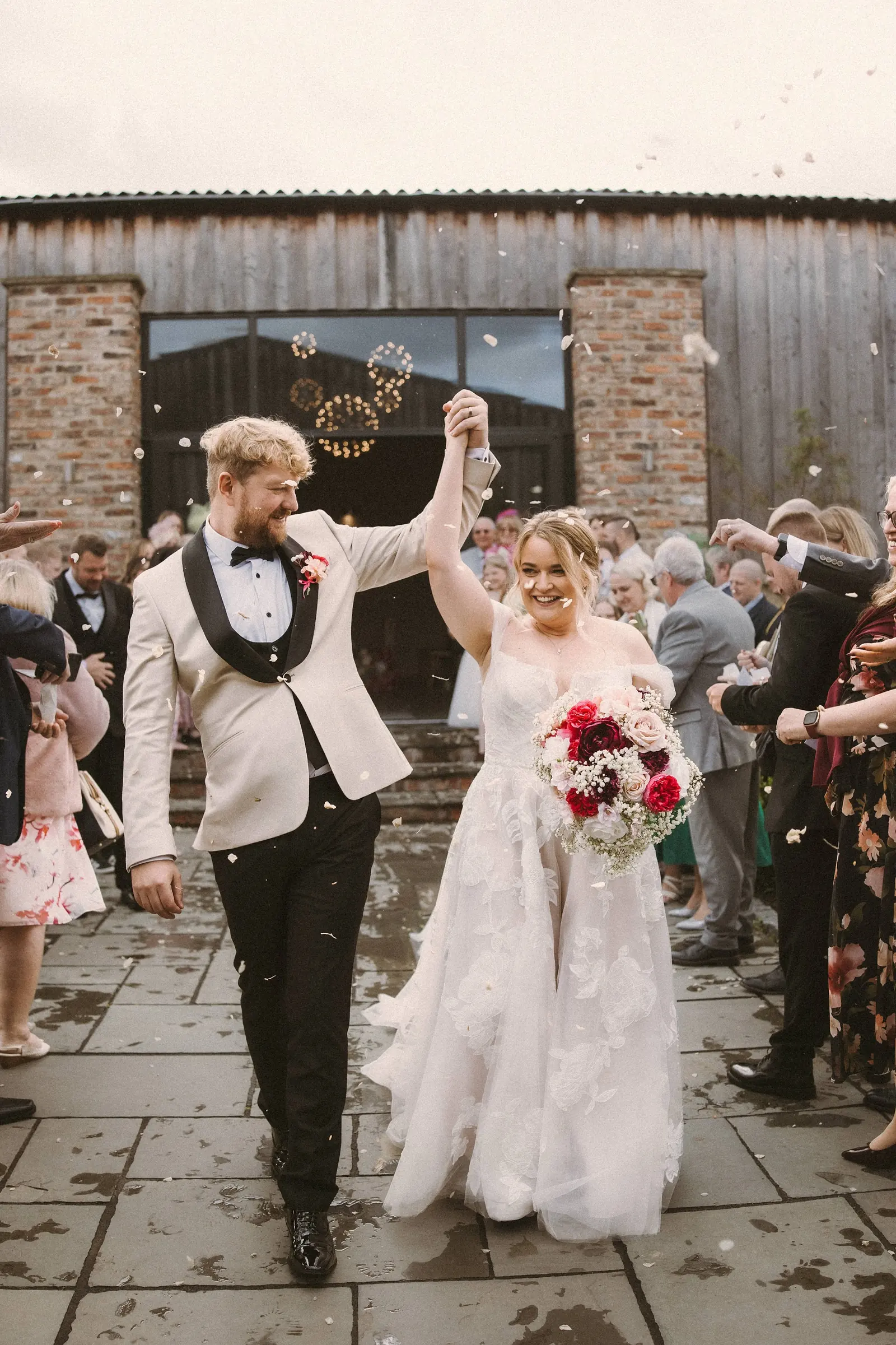 A couple celebrating as they walk through their guests