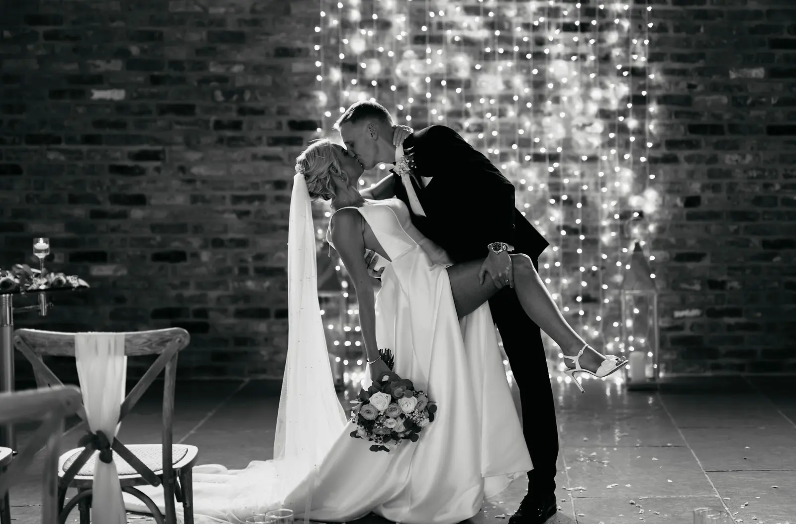 A couple kissing in front of the fairy light curtain